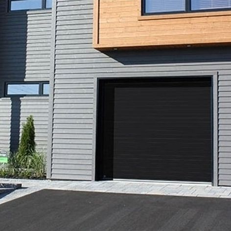 porte de garage noire installée dans une maison